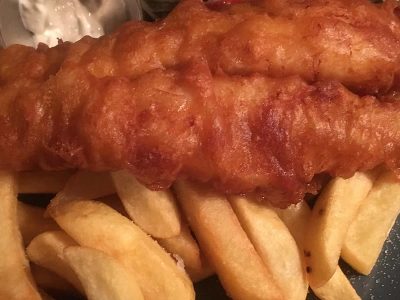 Golden battered fish and chips with lemon, tartare sauce and salad